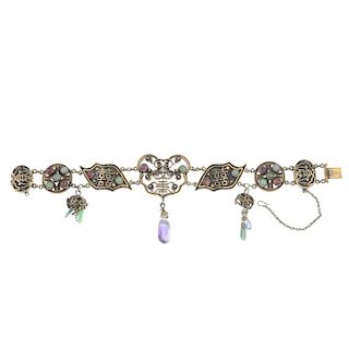 An oriental gem-set bracelet. The central openwork panel set with red and green gem cabochons, to th