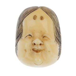 A late 19th century ivory Japanese Noh mask of Okame. Carved to show a smiling face with black hair,