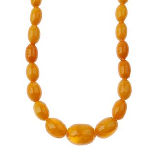 A natural amber bead necklace. Comprising thirty-one graduated oval-shape natural amber beads measur