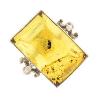 A 9ct gold natural amber ring with insect inclusion. The barrel-shape amber, with winged insect incl
