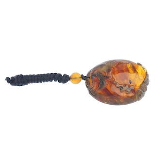 A carved Burmese root amber pendant. Carved to depict a bird of prey, said to bring luck in work lif