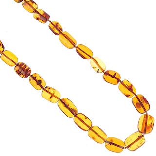 A reconstructed amber bead necklace. Comprising twenty-seven flat-rectangular reconstructed amber be