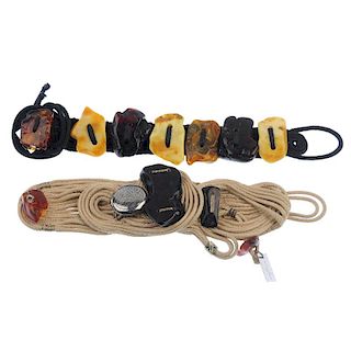 Two amber bracelets. The first designed as loops of black cord with freeform amber pieces fixed alon