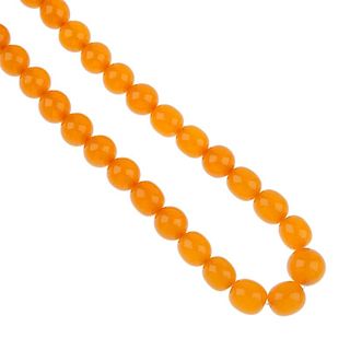 A reconstructed amber necklace and some loose plastic beads. The necklace designed as a series of gr