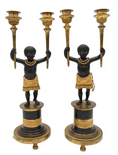 Near Pair of Directoire Ormolu and Patinated Bronze Candelabras, Aubon Sauvage, each modeled as Blackamoor holding two torches with dished gadrooned d