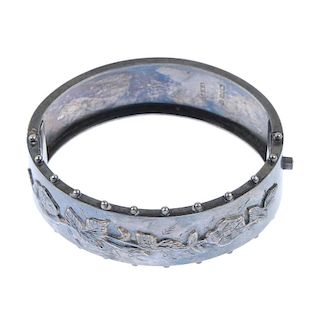 A late Victorian silver hinged bangle. With applied roses and leaves and beading to the edge of the