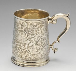 A George II silver mug, the tapered body with later floral scroll and scenic engraving surrounding t