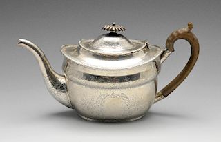 A Victorian silver teapot of oval form, the shaped body embellished with bright-cut floral scroll bo
