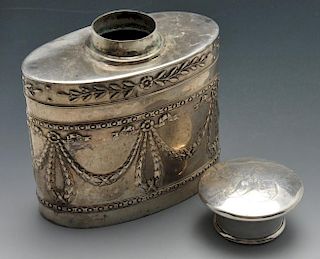 An early twentieth century silver tea caddy of oval form, decorated with a trailing leaf border abov