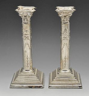 A pair of 1960's silver candlesticks, having raised garland swags tied with bows and pendant drops t