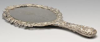 A late Victorian silver mounted hand mirror, the oval bevelled glass plate within an ornately pierce
