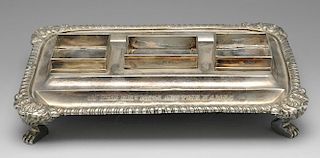 A George III silver desk stand of oblong form, having a gadroon rim with foliate shell borders and r