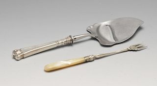 A Norwegian silver mounted cheese slice with tapered scroll embellished handle, marked Hestenes Norw
