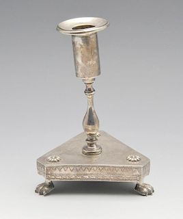 A South American candlestick of tri-form, florally embellished base raised on three paw feet and ris