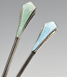 A cased set of Art Deco enamelled coffee spoons, the faceted bowls with shaped shoulders rising to t