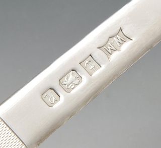 A modern silver letter opener, the plain tapering blade leading to the engine-turned handle. Hallmar