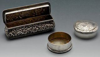 A late Victorian small silver box of oblong form, ornately embossed with floral and foliate scrolls