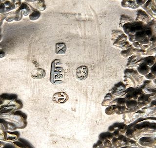 A George IV silver wine label, the scalloped scroll surround with fruiting vine, surmounted with Bac