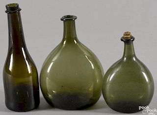 Two olive green blown glass bottles, early 19th c., together with a dark amber bottle