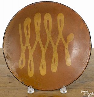 Redware charger, 19th c., probably Norwalk, Connecticut, with yellow slip loop decoration