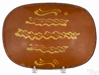 Pennsylvania redware loaf dish, 19th c., with yellow slip decoration, 9 3/4'' h., 13 1/2'' w.