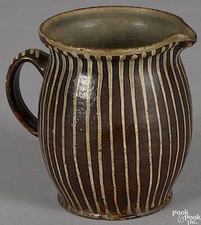 Redware pitcher, 19th c., with striped slip decoration, 6'' h.