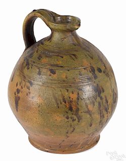New England redware bulbous pitcher, early 19th c., with a spout and incised concentric lines