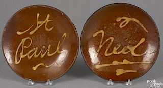 Two Connecticut redware plates, 19th c., with slip inscriptions St. Paul and Ned, 9'' dia.