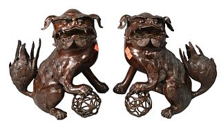 Pair of Bronze Yin Shi and Yang Shi Foo Dogs, each having paw raised on Xiuqiu ball, each height 12.5 inches.