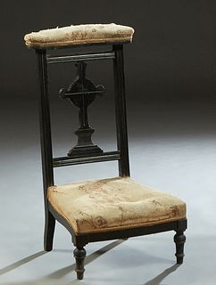 French Ebonized Beech Prie Dieu, c. 1870, the curved cushioned armrest over a cruciform back splat, to a bowed cushioned seat, on turned tapered legs,