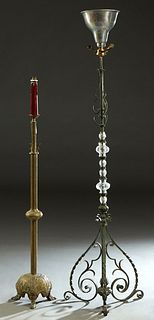 Two French Floor Lamps, early 20th c., one of relief brass, now with a faux candle atop a relief decorated square support, to a circular relief decora