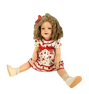 Composition Shirley Temple doll @ 23" tall by Ideal. Some craquelure on body, replaced wig. Her left hand pinkie finger has damage. Darkened sleep eye