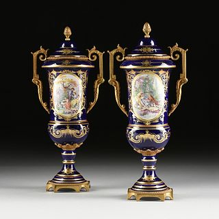 A PAIR OF SÈVRES STYLE PARCEL GILT AND ORMOLU MOUNTED BLUE GROUND LIDDED URNS, MARKED, 20TH CENTURY,