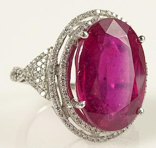 Lady's 18.41 Karat Oval Brilliant Cut Ruby and 14 Karat White Gold Ring accented with small Round Brilliant Cut Diamonds. Ruby with very fine color an