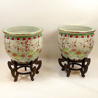 Large Pair Mid 20th Century Chinese Jardinières on Carved Wood Stands. Signed with pseudo Qian Long Mark. Measures 19" H x 22-3/4" dia. Shipping: Thi