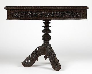 An Anglo-Indian carved wood flip-top game table