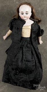 Bisque head and shoulder doll, 19th c., with a closed mouth, sleep eyes, and a leather kid body