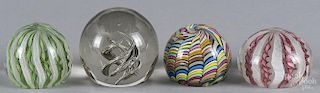 Four art glass paperweights, to include two Murano style ribbon and latticino paperweights