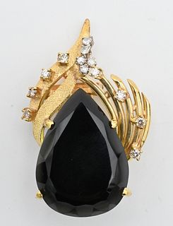 18 Karat Pendant/Brooch, having pear shaped onyx, 25 x 18 x 9 millimeters, set with 13 diamonds, 15.5 grams total weight.