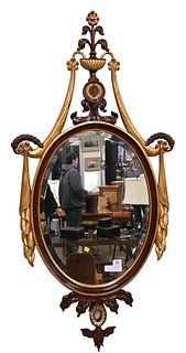 Oval Beveled Glass Mirror, having urn and drape carving, attributed to Maitland Smith, height 58 inches.