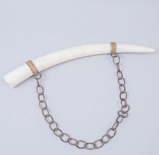 Colmillo de elefante. Origen africano. Siglo XX. Marfíl. Con anillos y cadena removibles. 60 cm longitud.