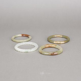 A GROUP OF FOUR JADE BANGLES 