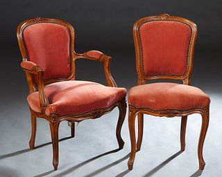 Two French Carved Beech Parlor Chairs, early 20th c., consisting of a fauteuil and a side chair, the arched canted floral carved shield back, to an up