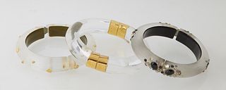 Five Pieces of Alexis Bittar Lucite Jewelry, 20th c., consisting of three hinged bangle bracelets, a floriform brooch, and a black and white oval pend