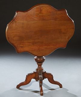 French Carved Walnut Louis Philippe Lamp Table, late 19th c., the rounded edge tortoise top on a turned urn support to four leaf carved cabriole legs,