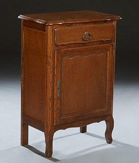 Diminutive Louis XV Style Carved Oak Confiturier, 20th c., the bowed stepped edge rounded corner top over a frieze drawer and a fielded panel cupboard