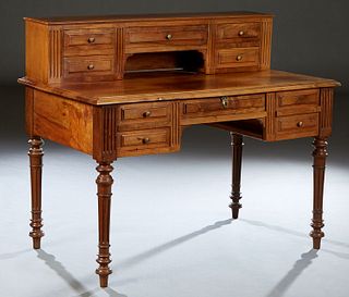 French Louis Philippe Style Carved Walnut Desk, late 19th c., with a superstructure with five fitted drawers flanked by reeded pilasters, on a stepped