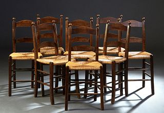 Set of Eight French Provincial Carved Beech Rush Seat Dining Chairs, early 20th c., the arched canted ladder back over a woven rush seat, on tapered s
