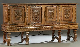 French Renaissance Style Carved Oak Sideboard, early 20th c., the stepped carved edge crown over double fielded panel cupboard doors with heraldic car