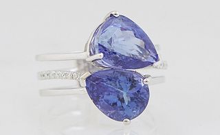 Lady's 18K White Gold Dinner Ring, with two pear shaped 4.42 carat tanzanites, atop a triple split band, the center band with tiny diamond mounted sho
